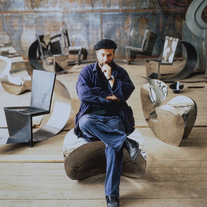 Ron Arad, 1991, sitting on Big Heavy (1989), in the background Rietveld Chair (1990) and Little Heavy (1989). © Vitra Archive