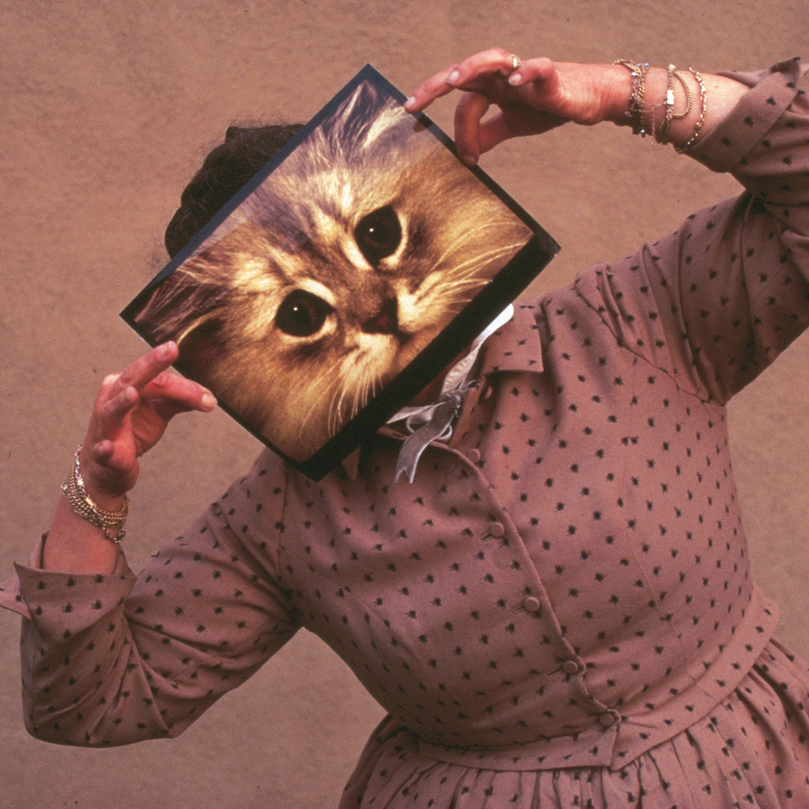 Ray Eames posing with a cat photograph, December 1970 © Eames Office LLC